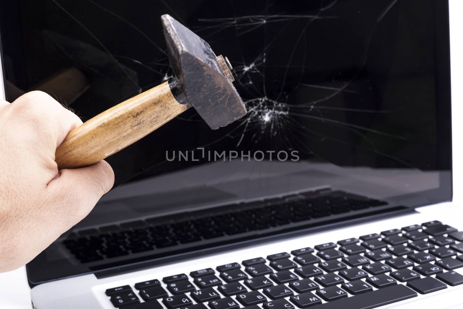 Hand breaking laptop screen with a hammer 