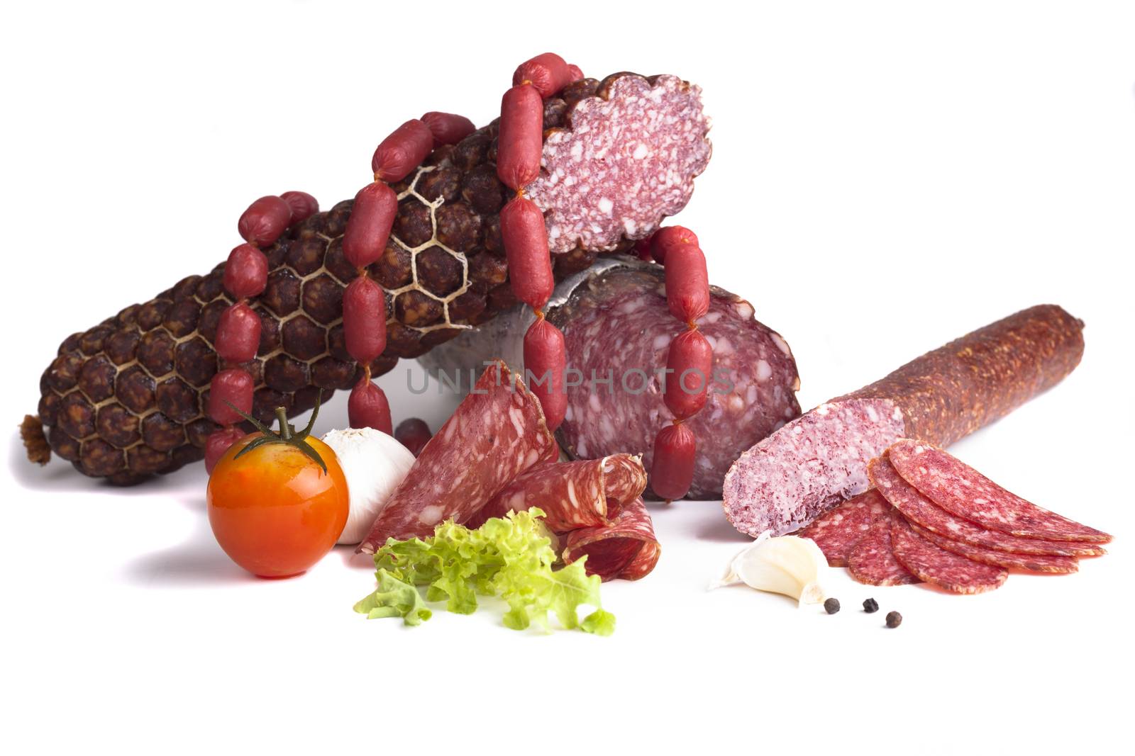 Various salami products in a with tomato isolated on white background