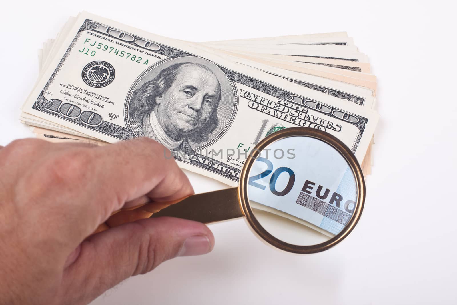 magnifying a hundred dollar bill with golden color loupe showing 20 euro bill on white background