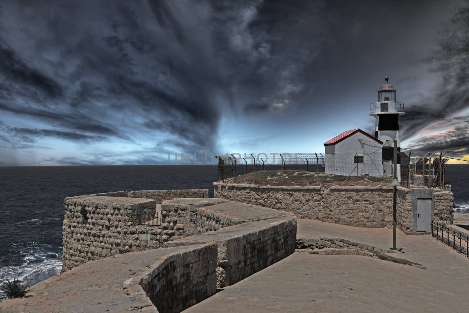 Lighhouse at the end of ancient wall at dusk