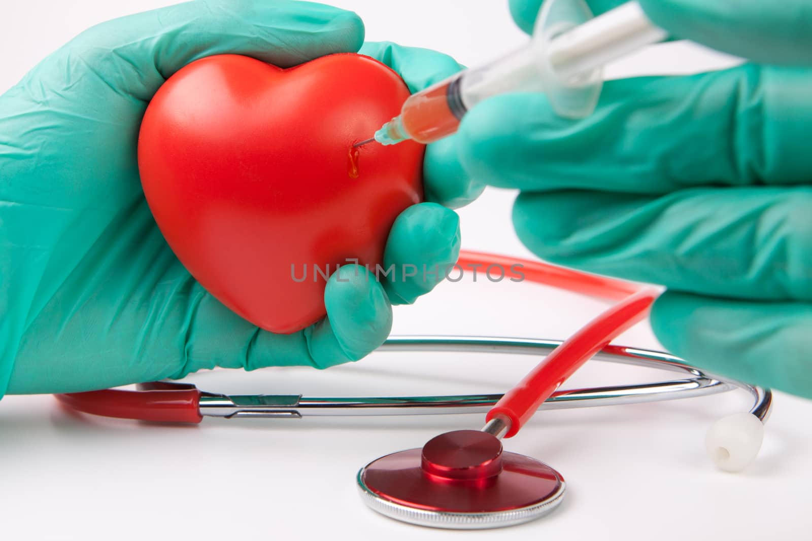 injecting red heart with blood green gloves and a red stethoscope on white background