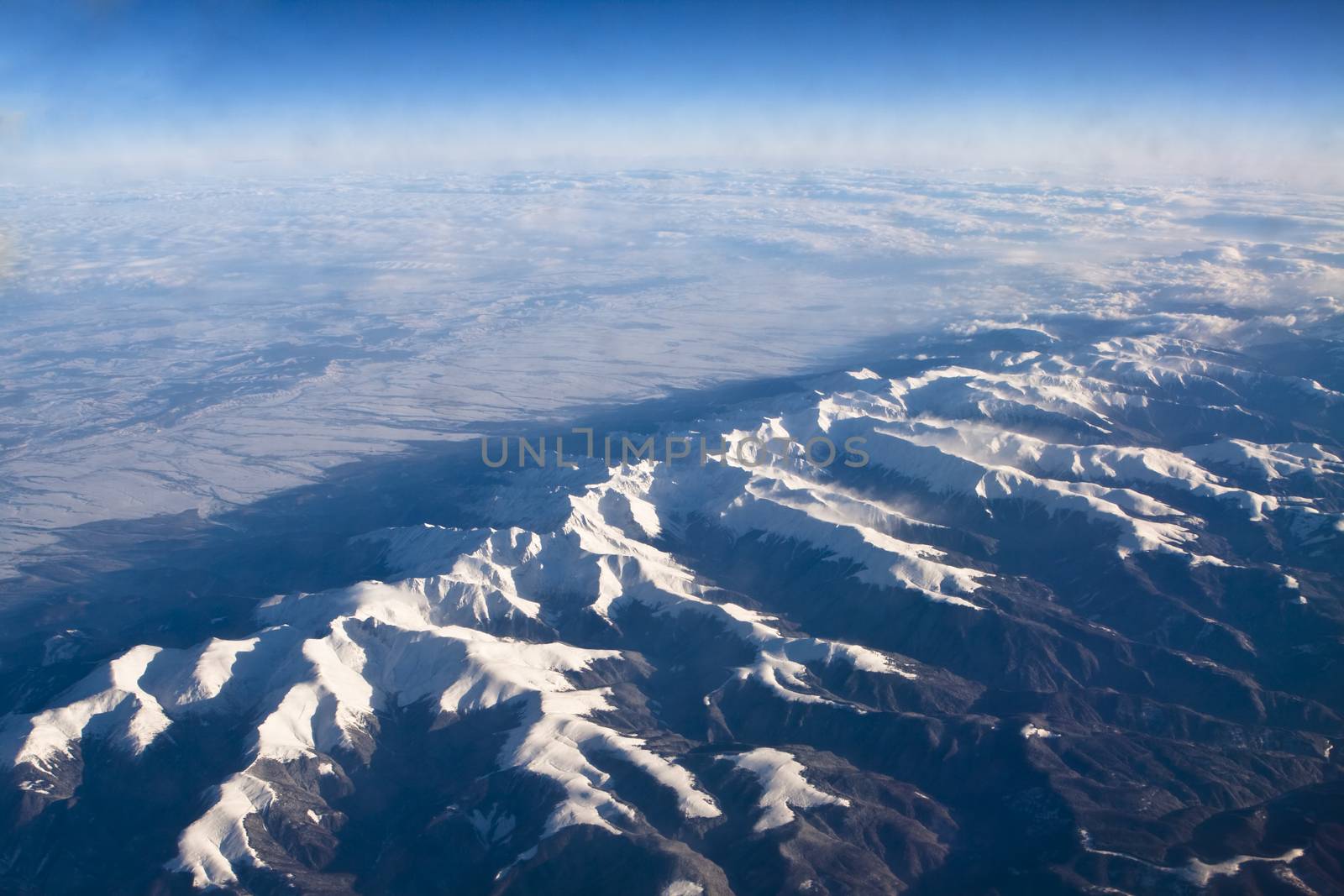 rocky mountains covered with snow aerial view from airplane