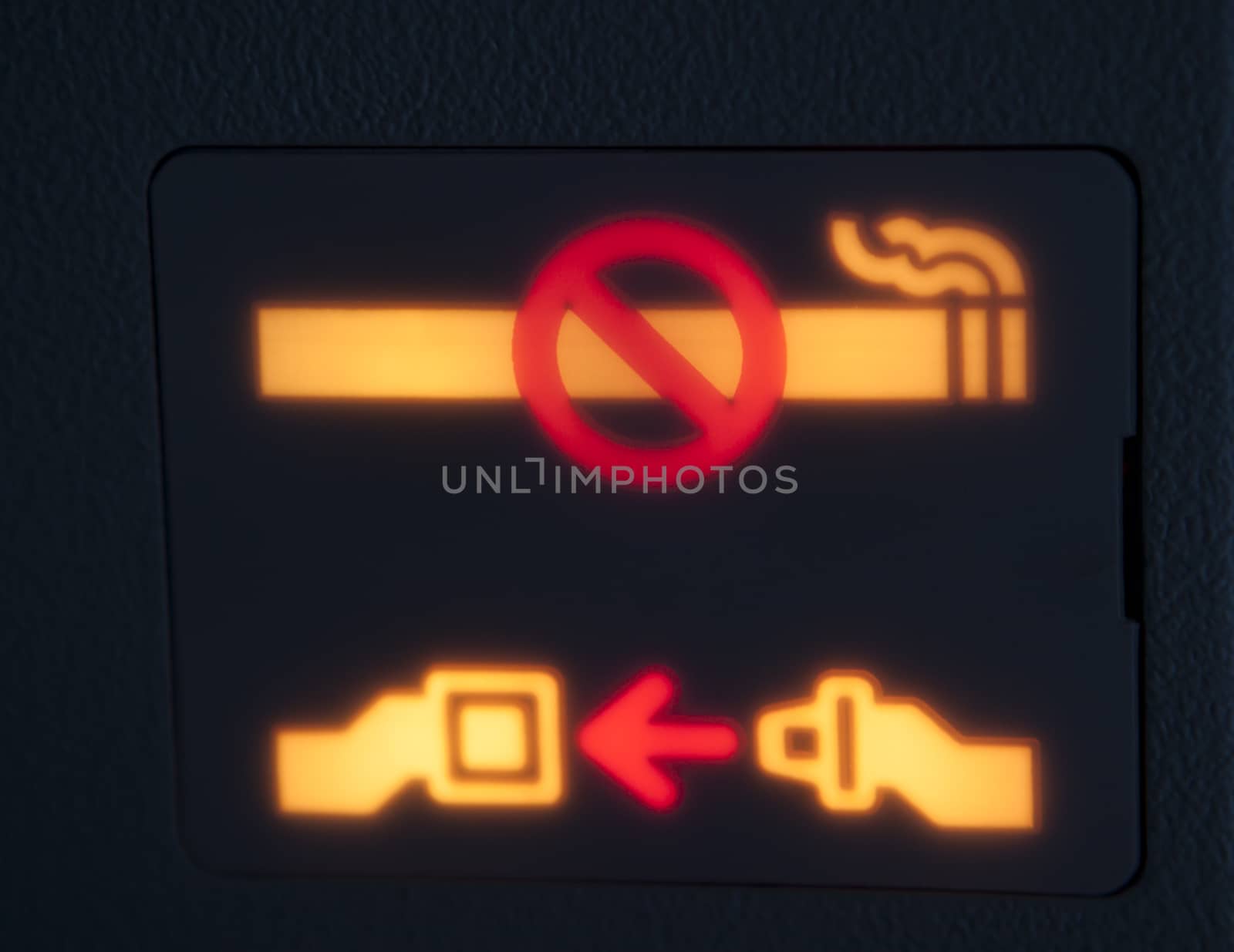 seatbelt and no smoking warning signg in an airplain