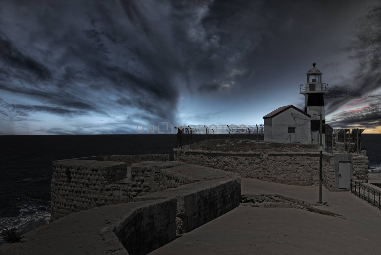 Lighhouse at the end of ancient wall at dusk