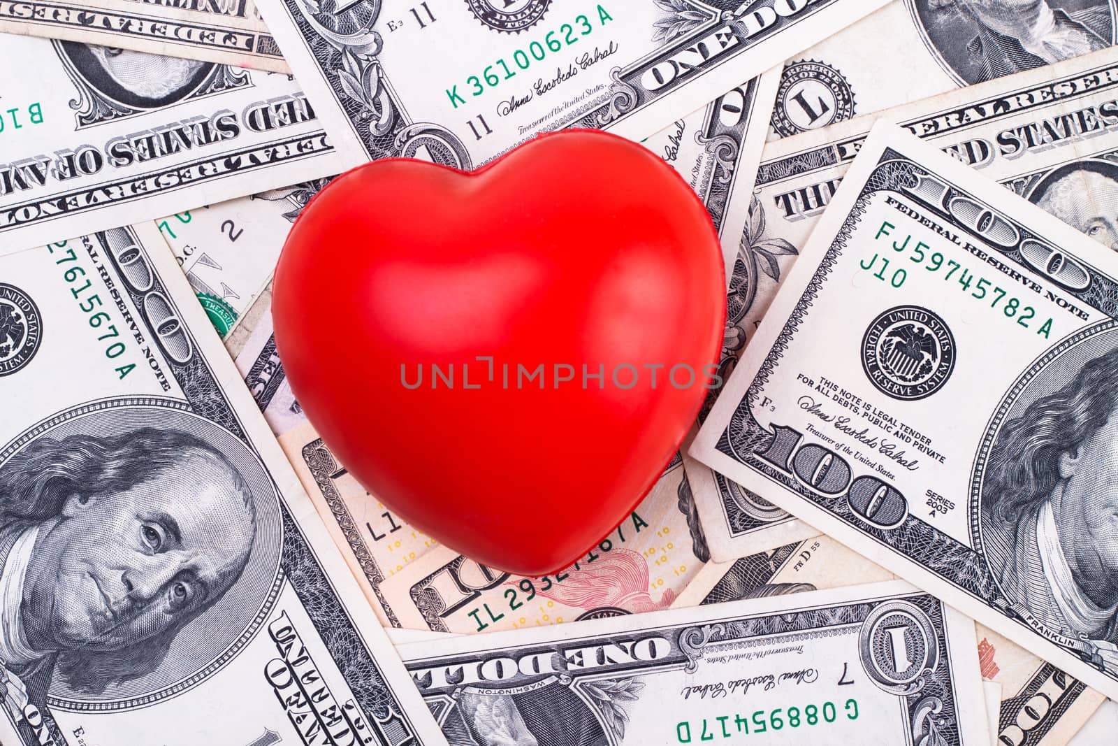 red heart on top of dollar bank notes