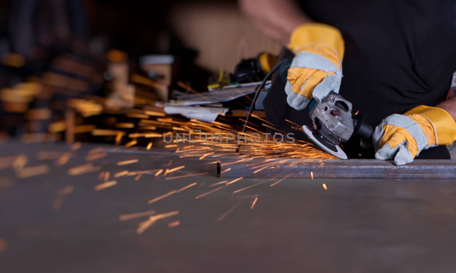 industrial grinding sparks with worker and protective mask and gloves