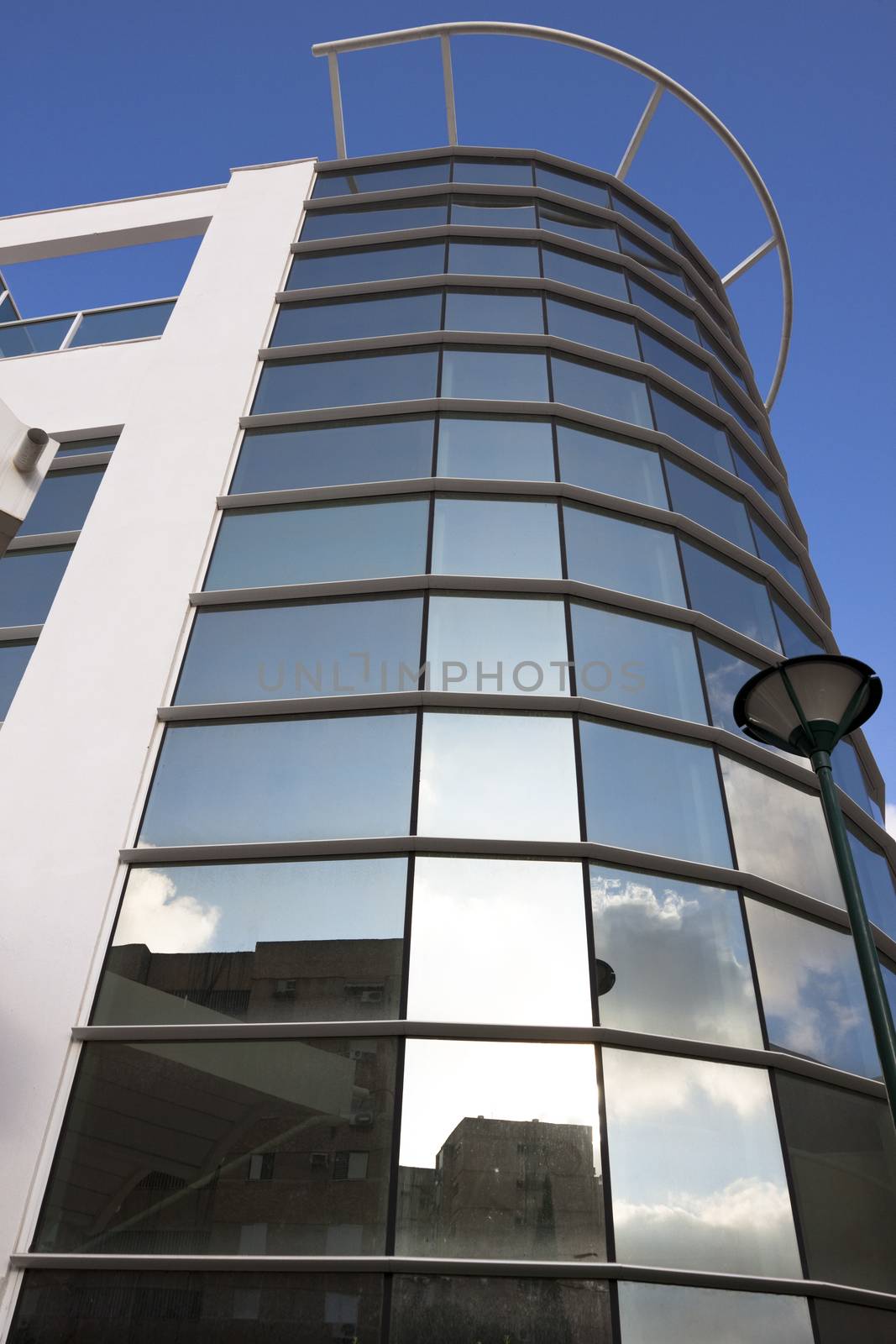 round glass office bulding exterior with blue sky in the background