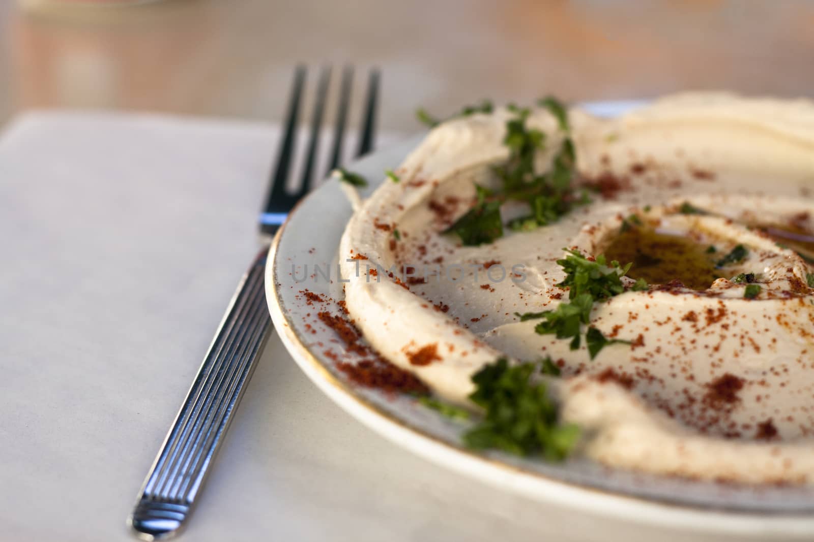 traditional humus dish with olive oil paprika and parsley