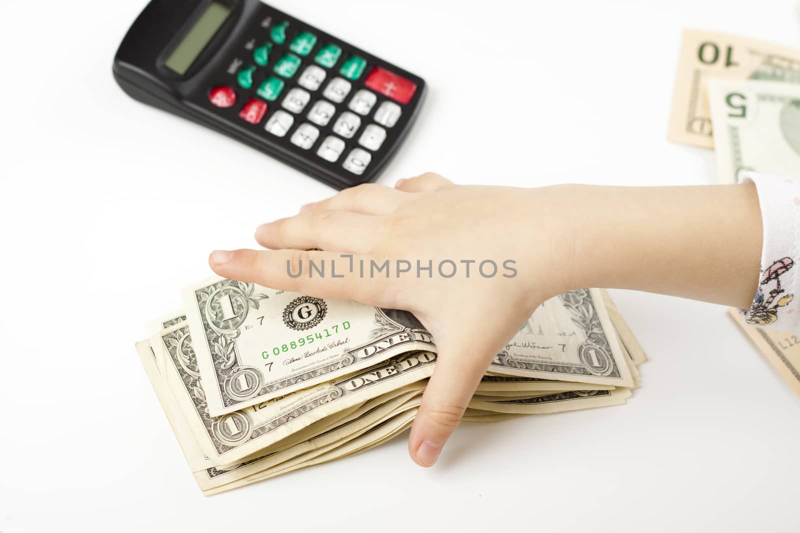 hand separating dollars by type on white background and a black calculator