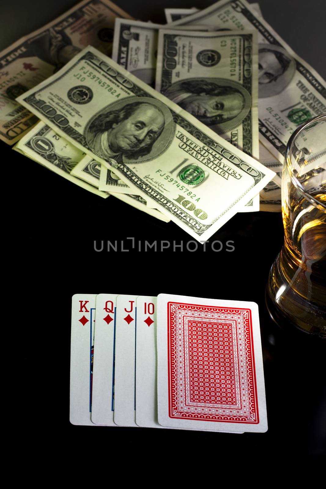 poker playing cards dollars and a wiskey glass