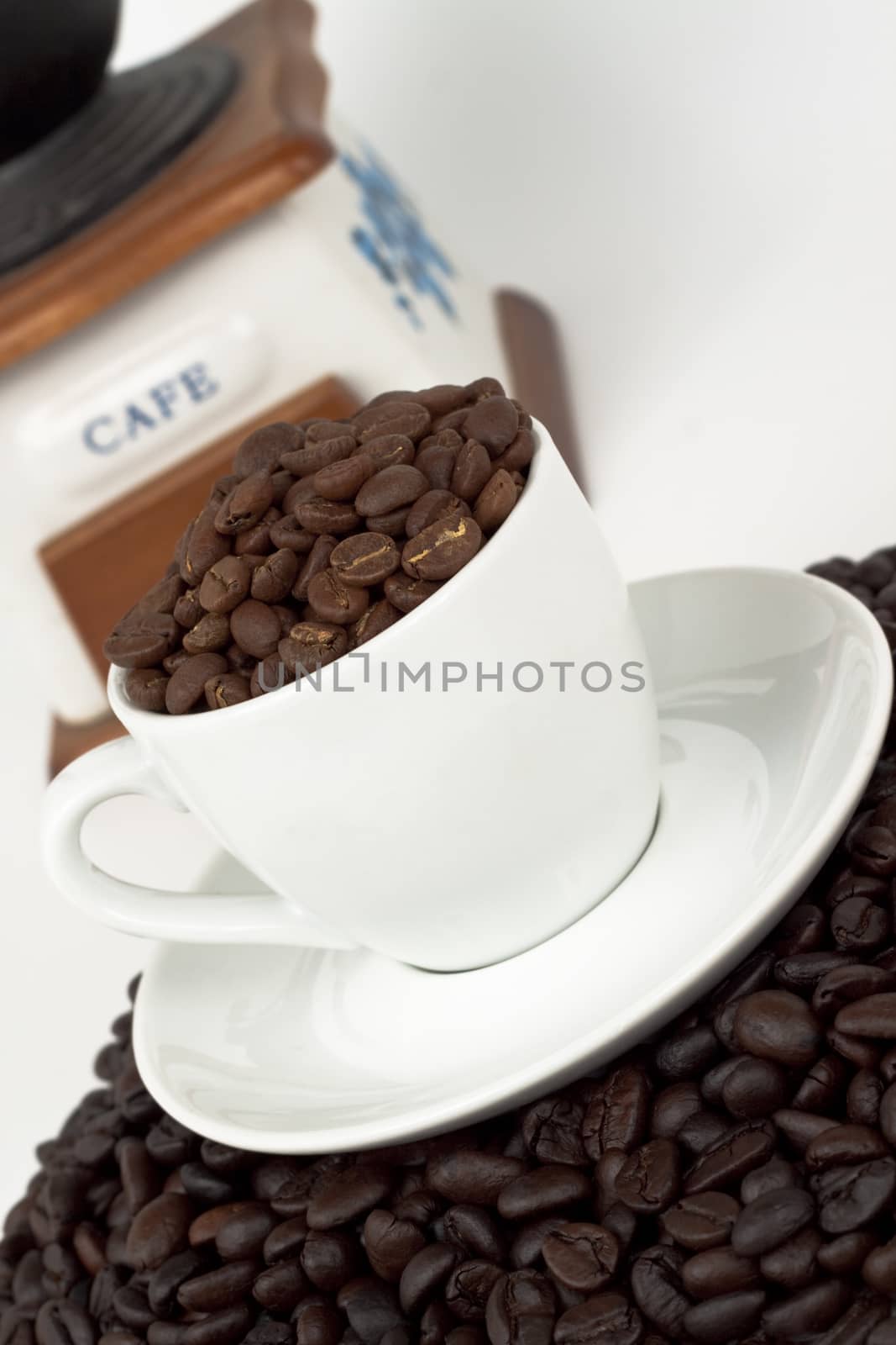 white coffee cup with beans and a coffee grinder on white background