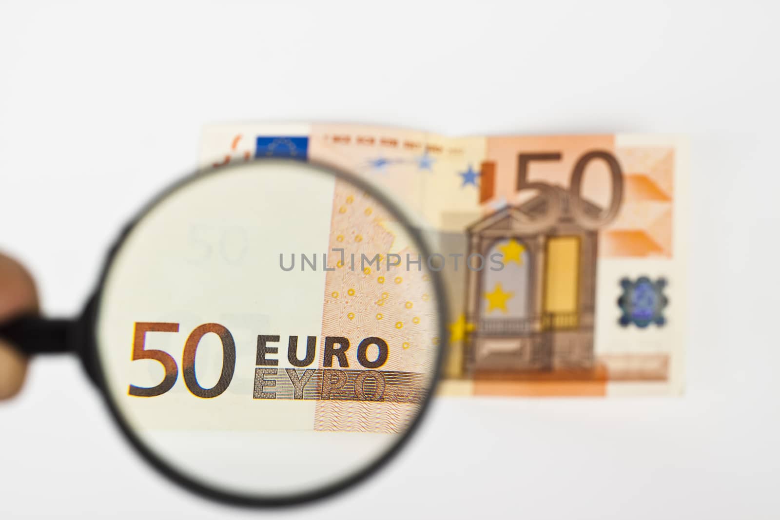 fifty  euro with magnifying glass on white background
