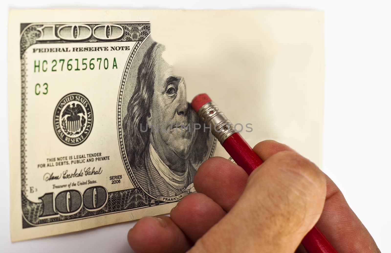erasing a 100 dollar bill with a red pencil and eraser