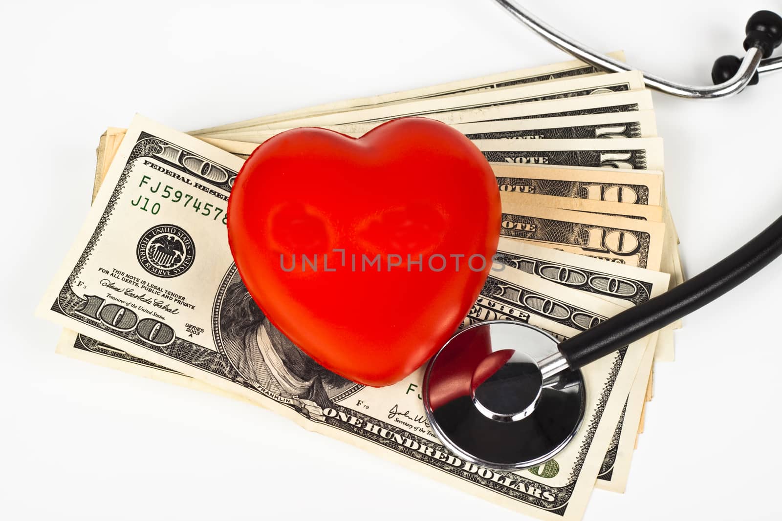 red heart dollar bills and a stethoscope on white background