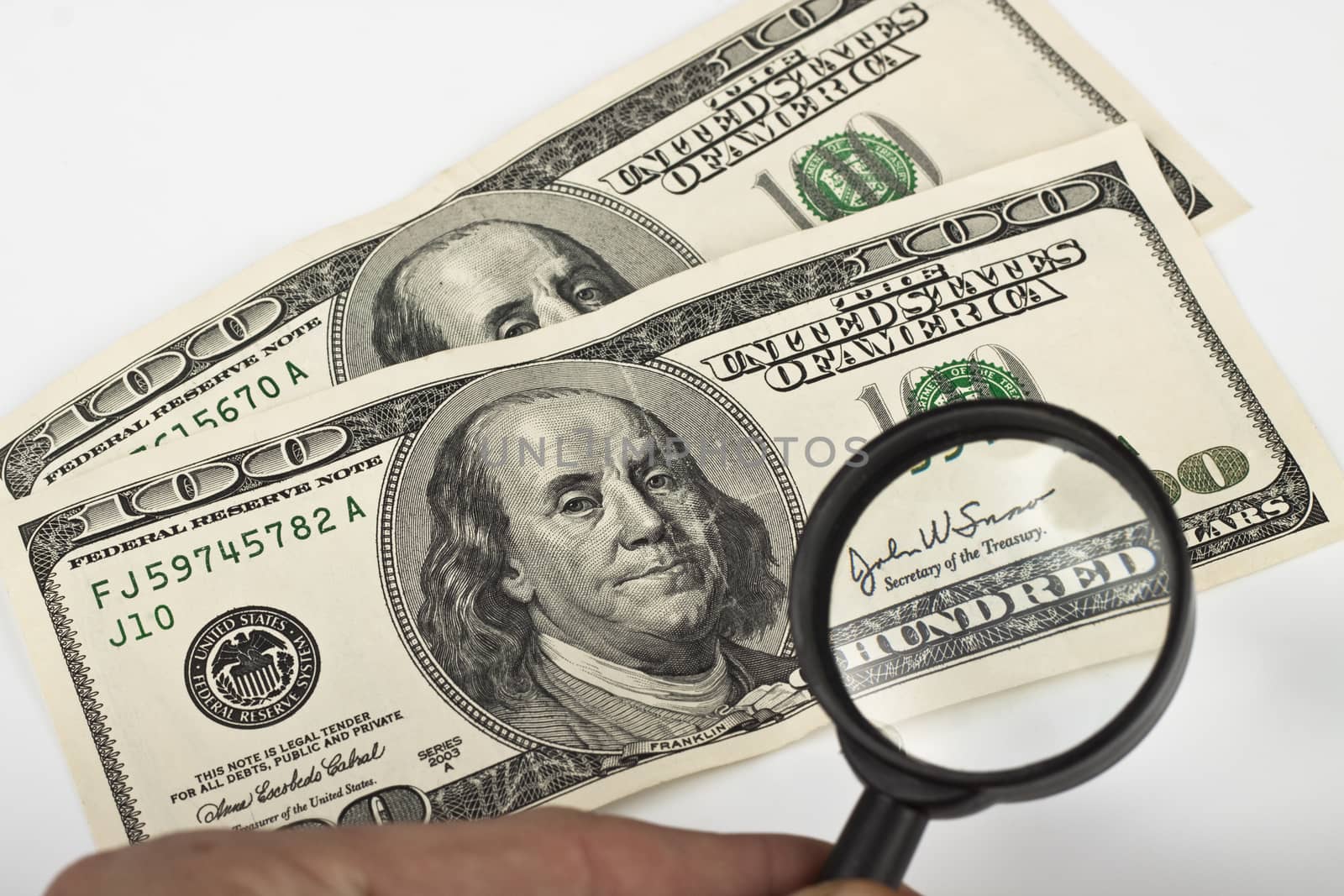 magnifying a dollar bill with a magnifying glass on white background