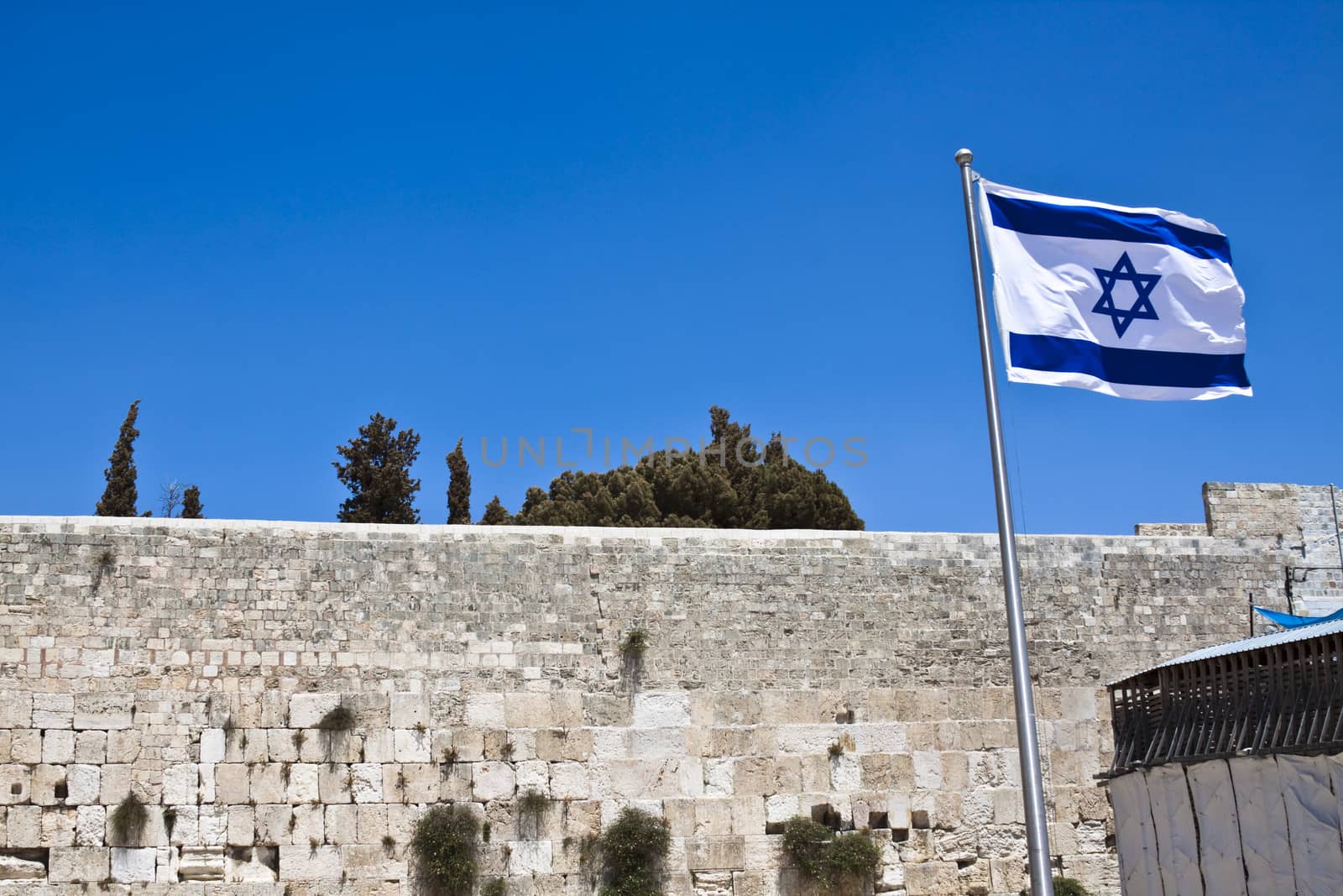 israelian flag with the western wall in the background  and blue sky