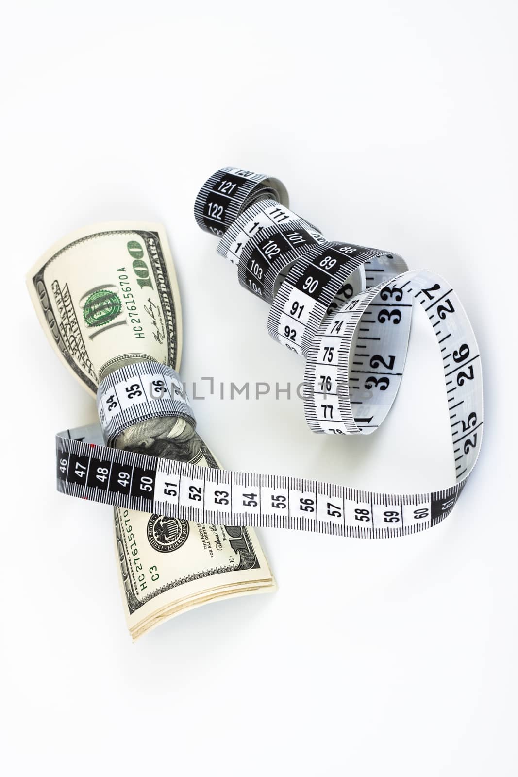 100 dollar bills tight with a measuring tape on white background