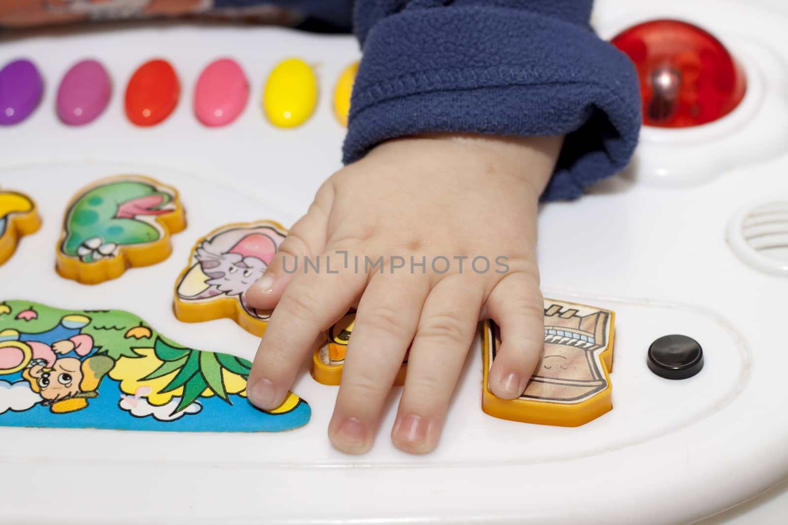 a small baby hand on a collorful toy