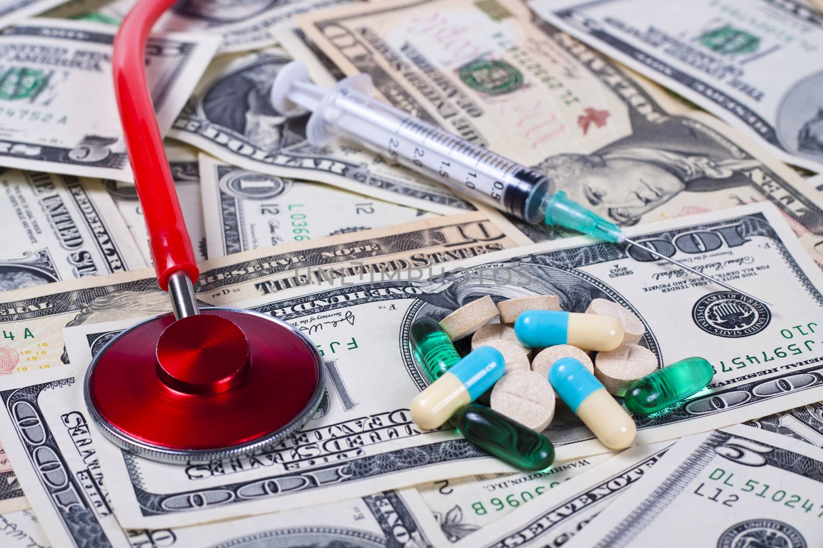 dollars  colored pills seringe and a red stethoscope