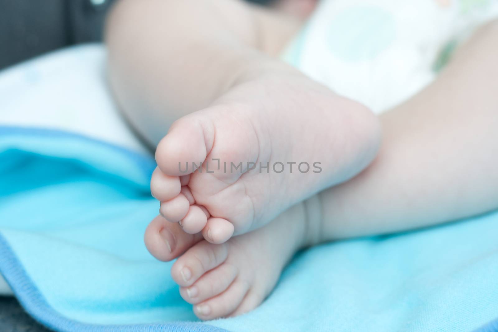 baby foot on each other blu ebackground selective focus