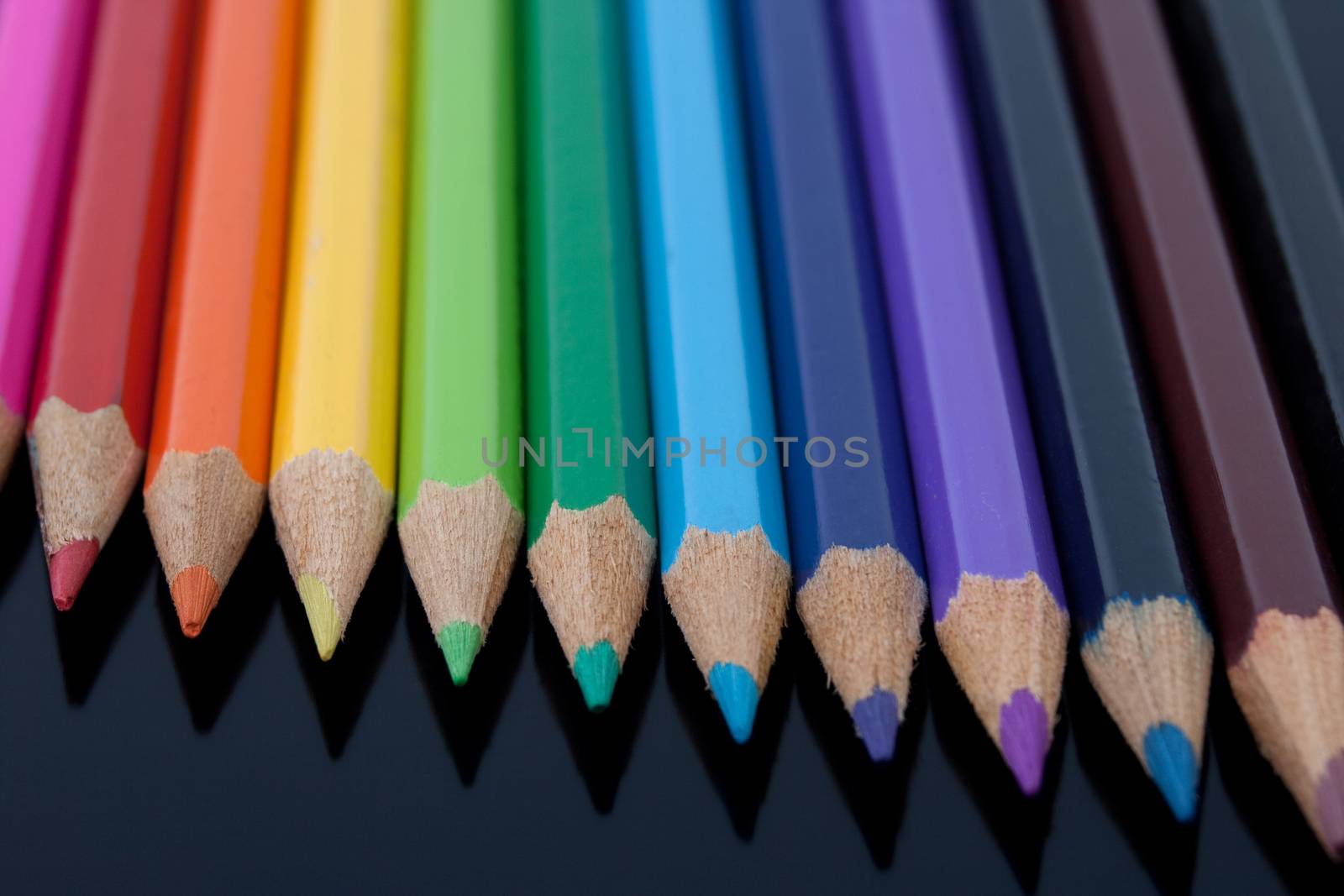 colored pencils closeup on black reflective background