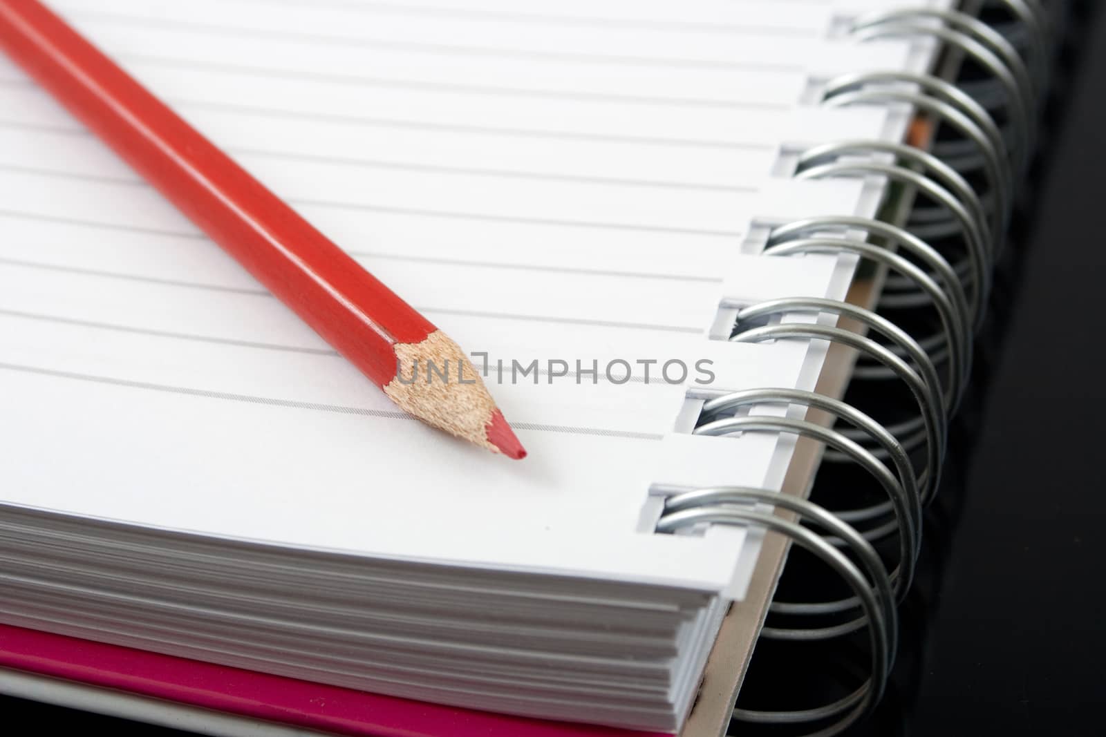 red pencil and a spiral notebook