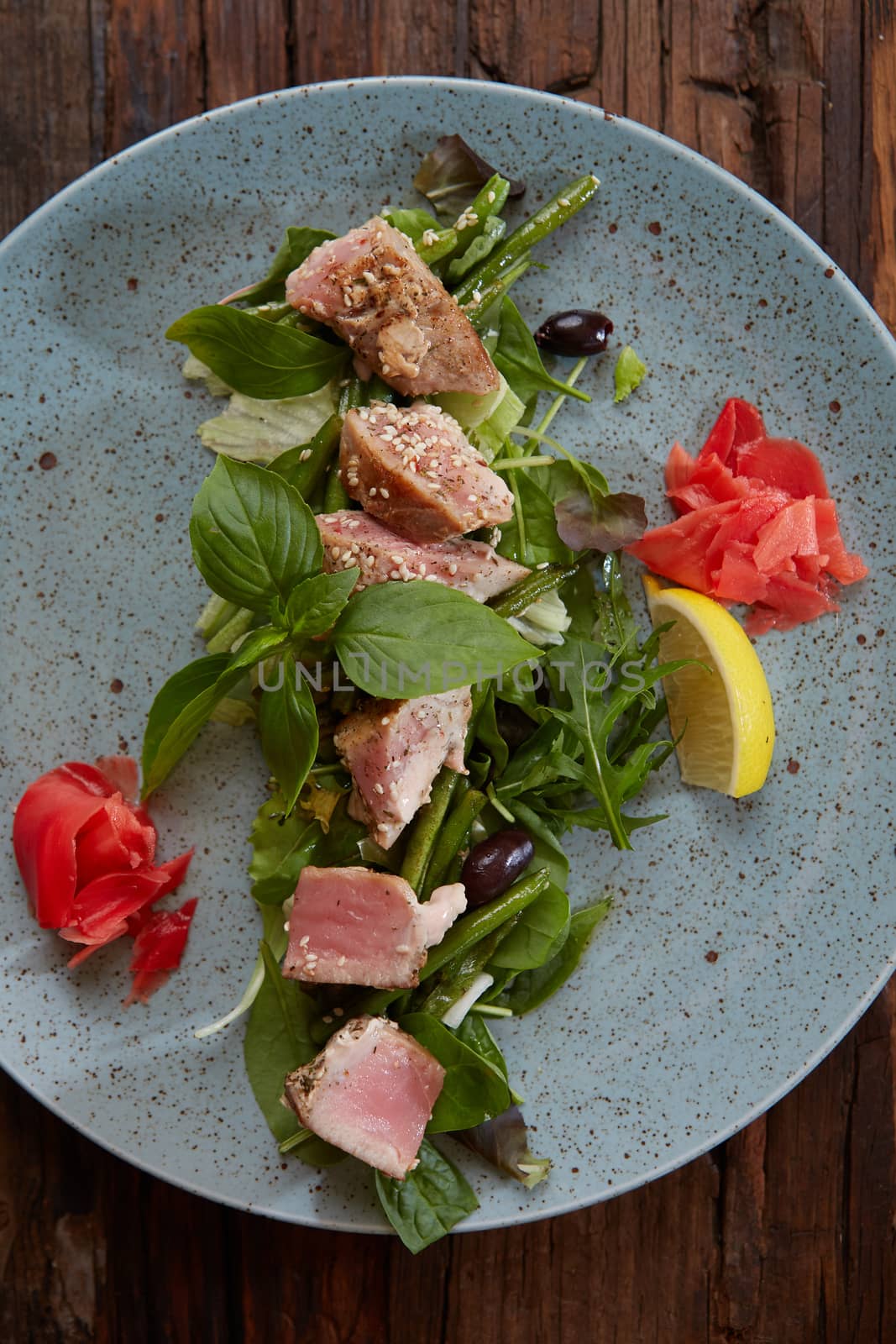 beautiful food: steak tuna in sesame, lime and fresh salad close-up on a plate on the table