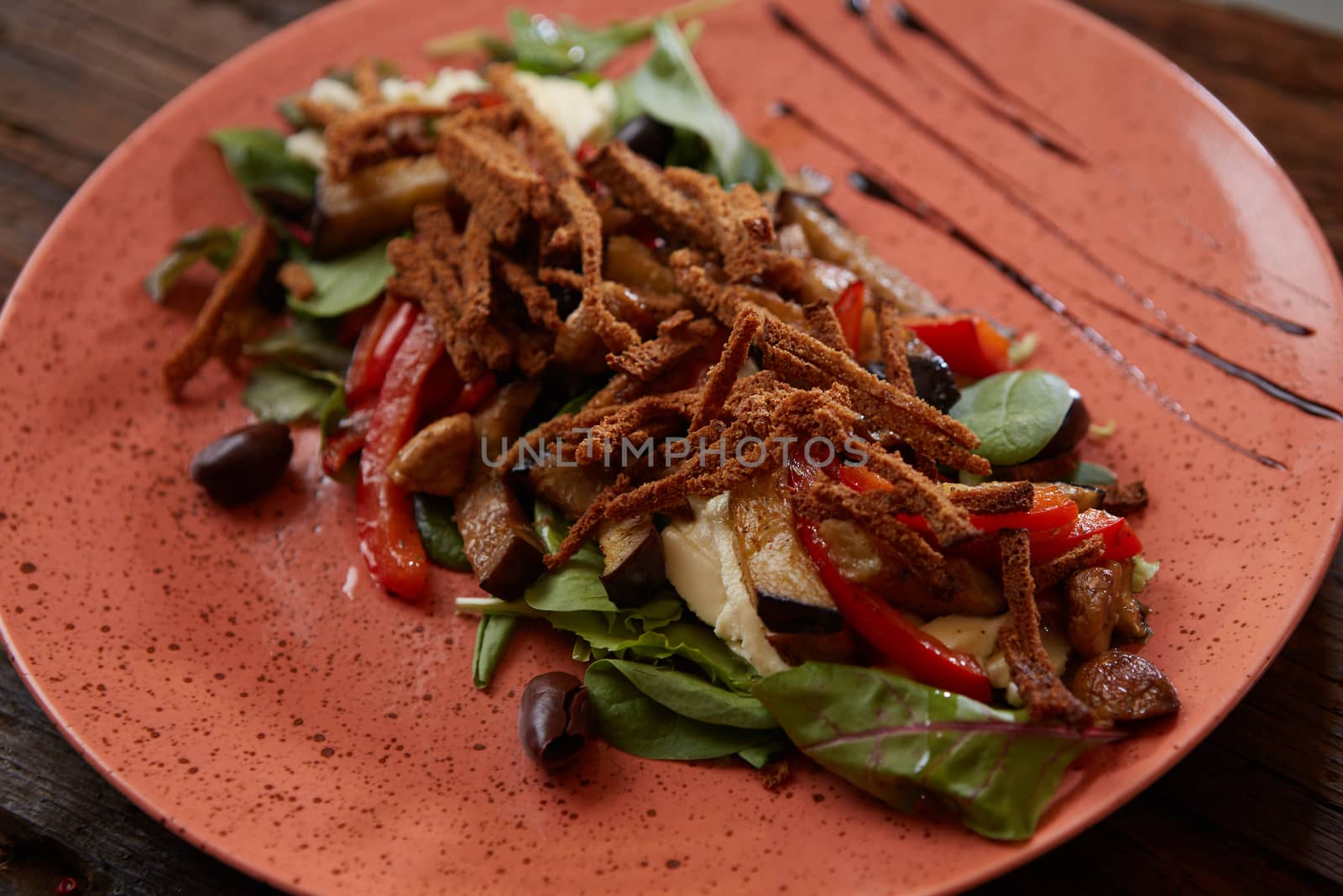 Salad baked eggplant with green onions, croutons and tomatoes on wooden background