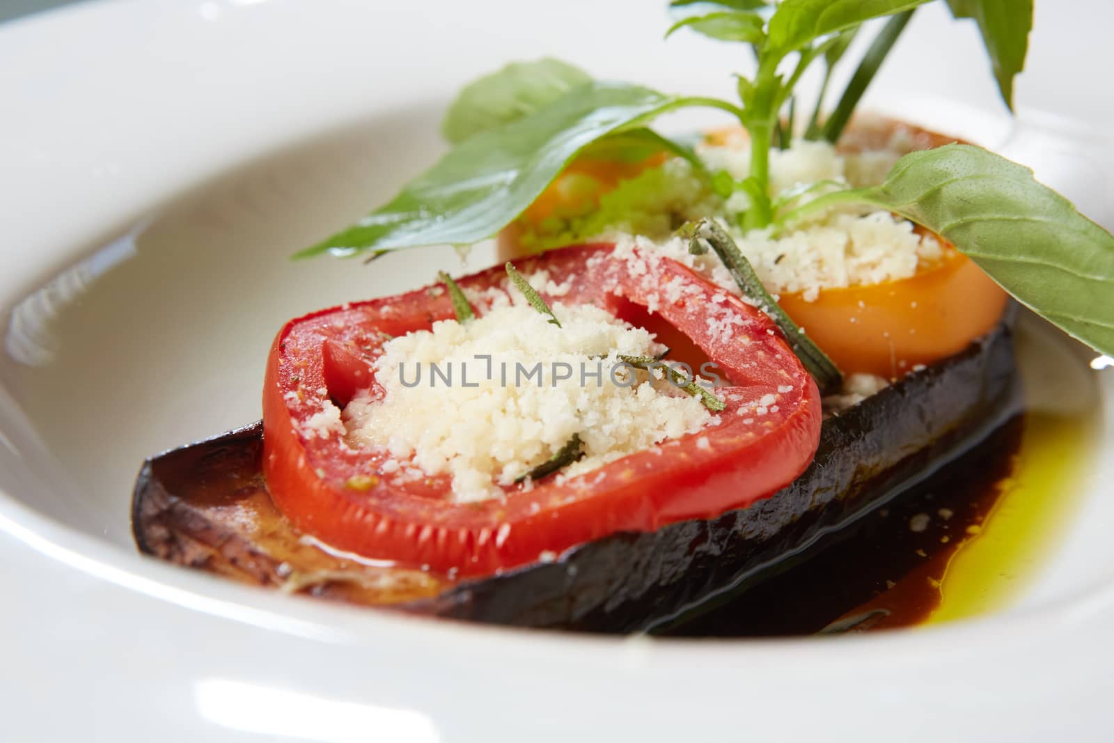 Baked eggplant with parmesan cheese, tomatoes and basil