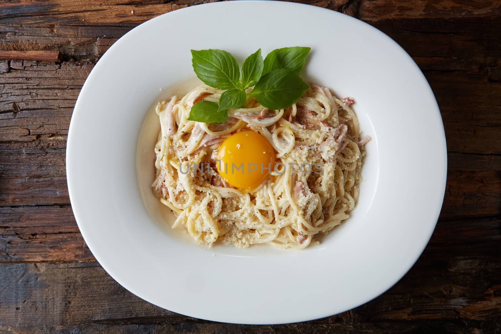 Pasta Carbonara on white plate with parmesan.