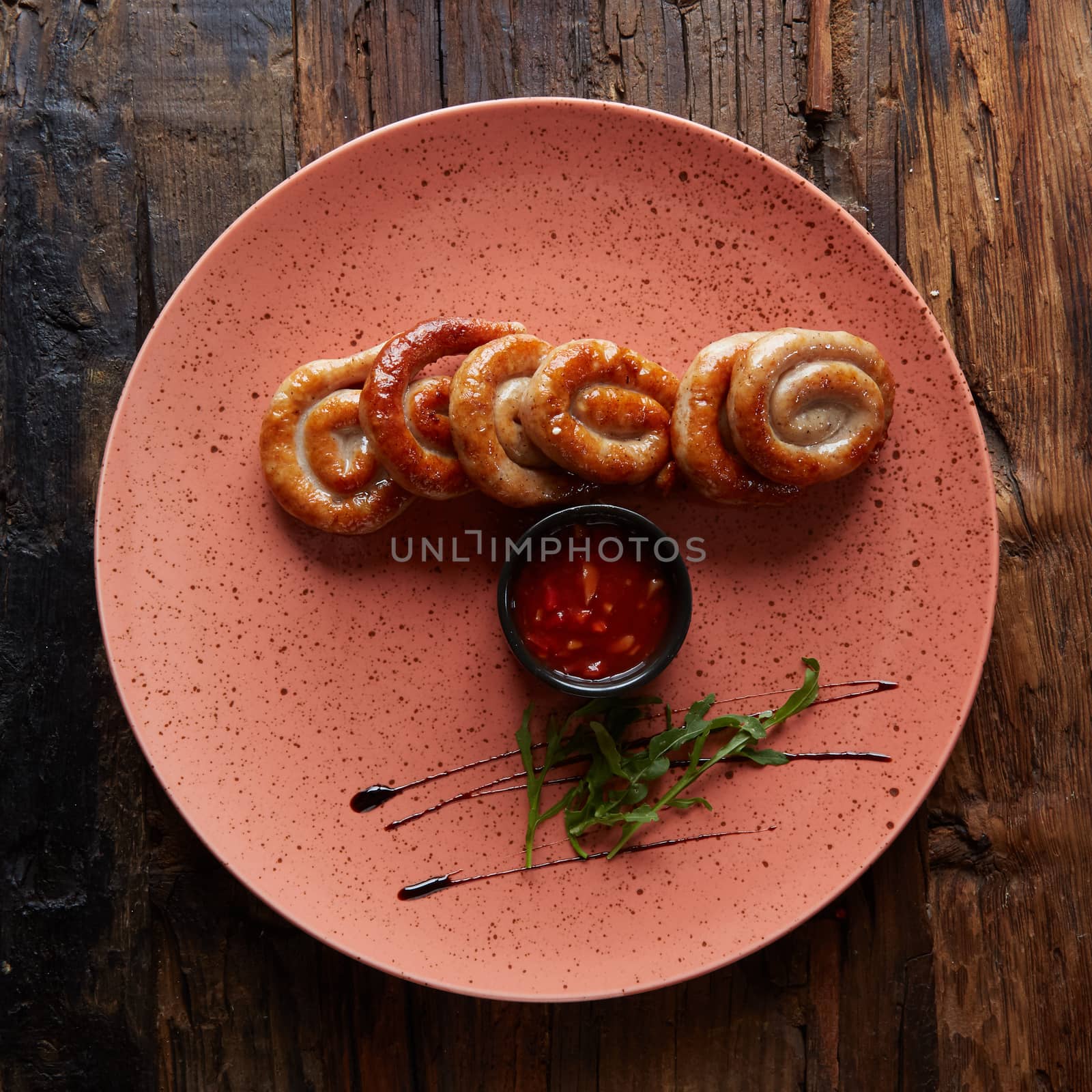 Grilled sausages in plate, top view