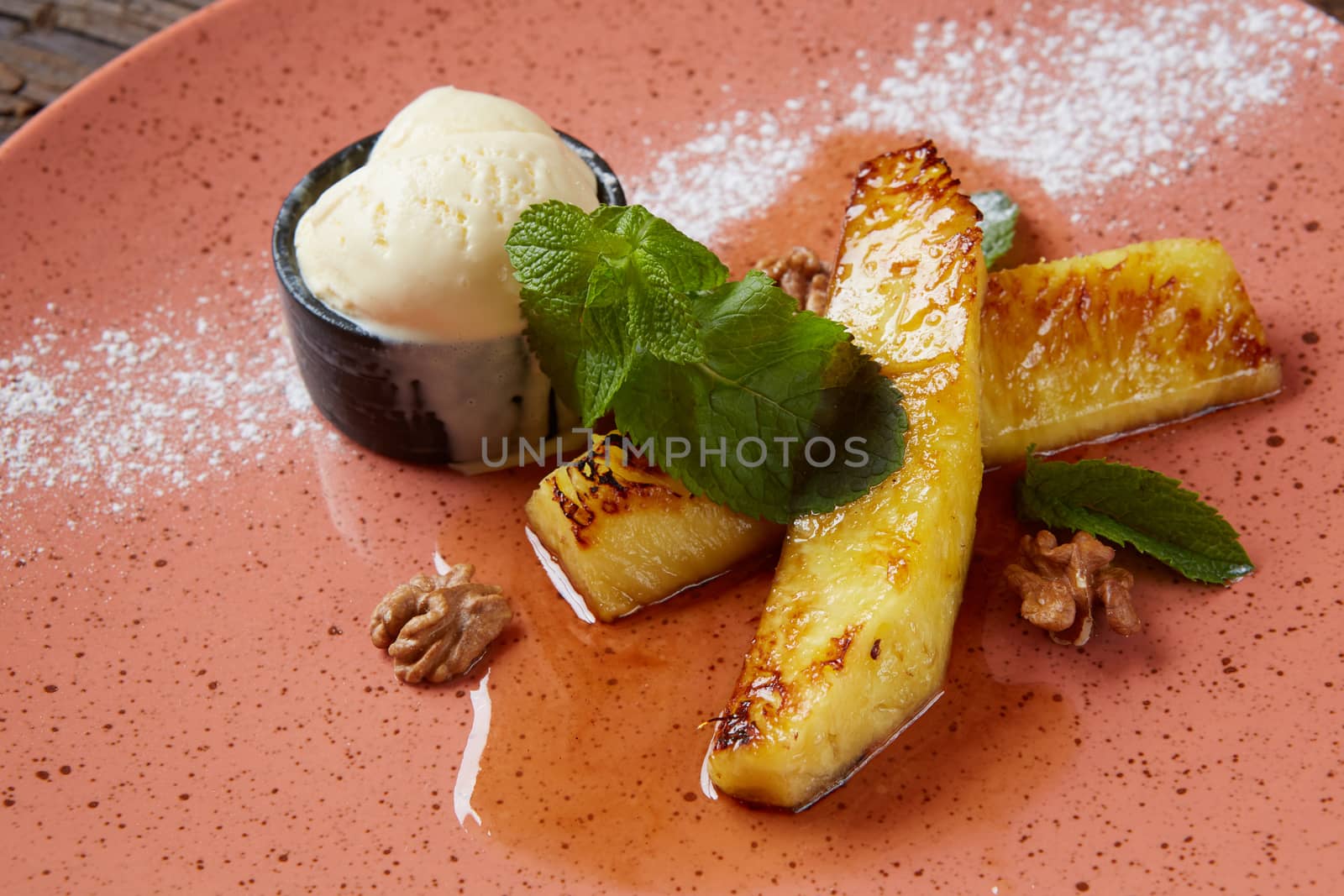 Grilled pineapple with scoops of vanilla ice cream