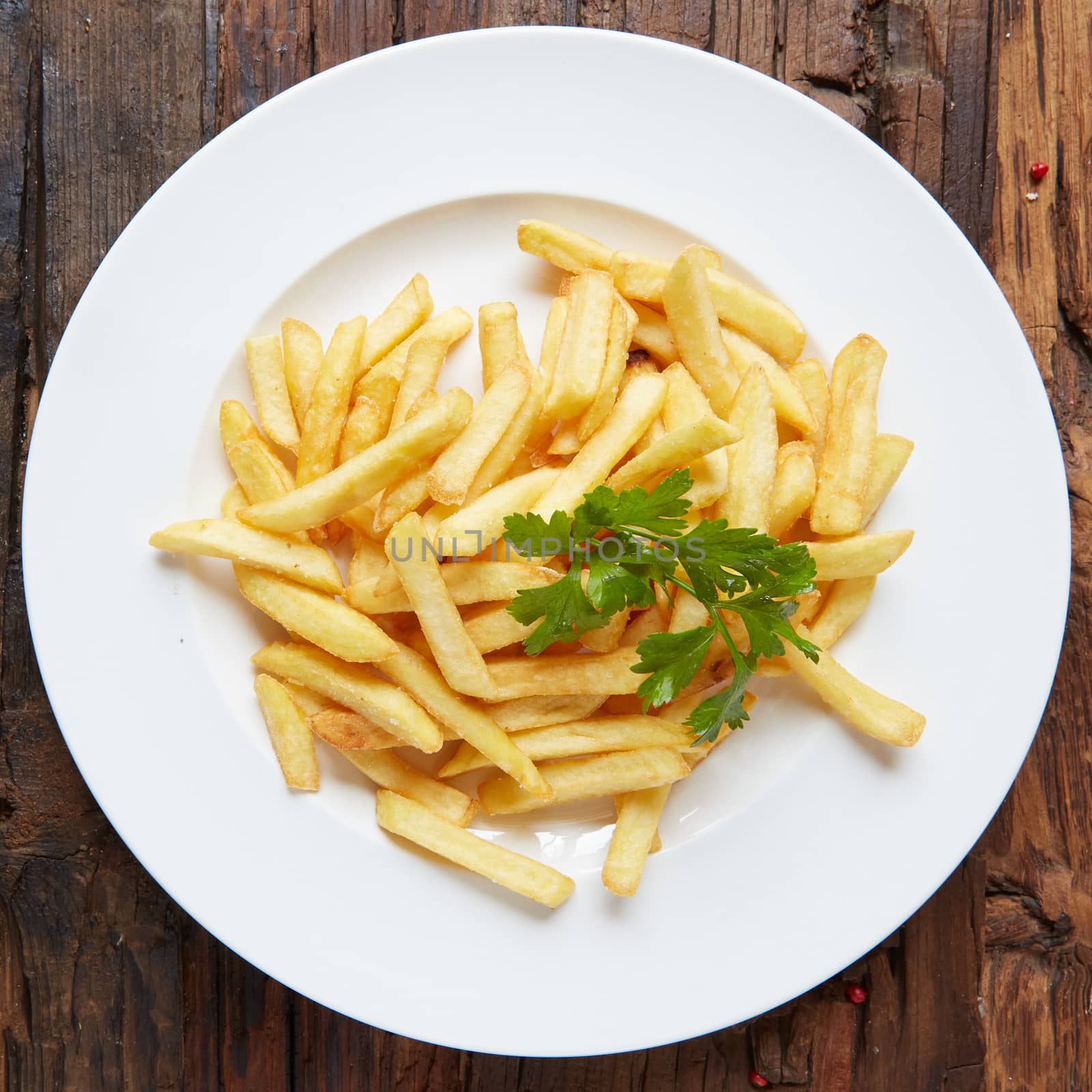 French fries in a bowl on a wooden background. by sarymsakov