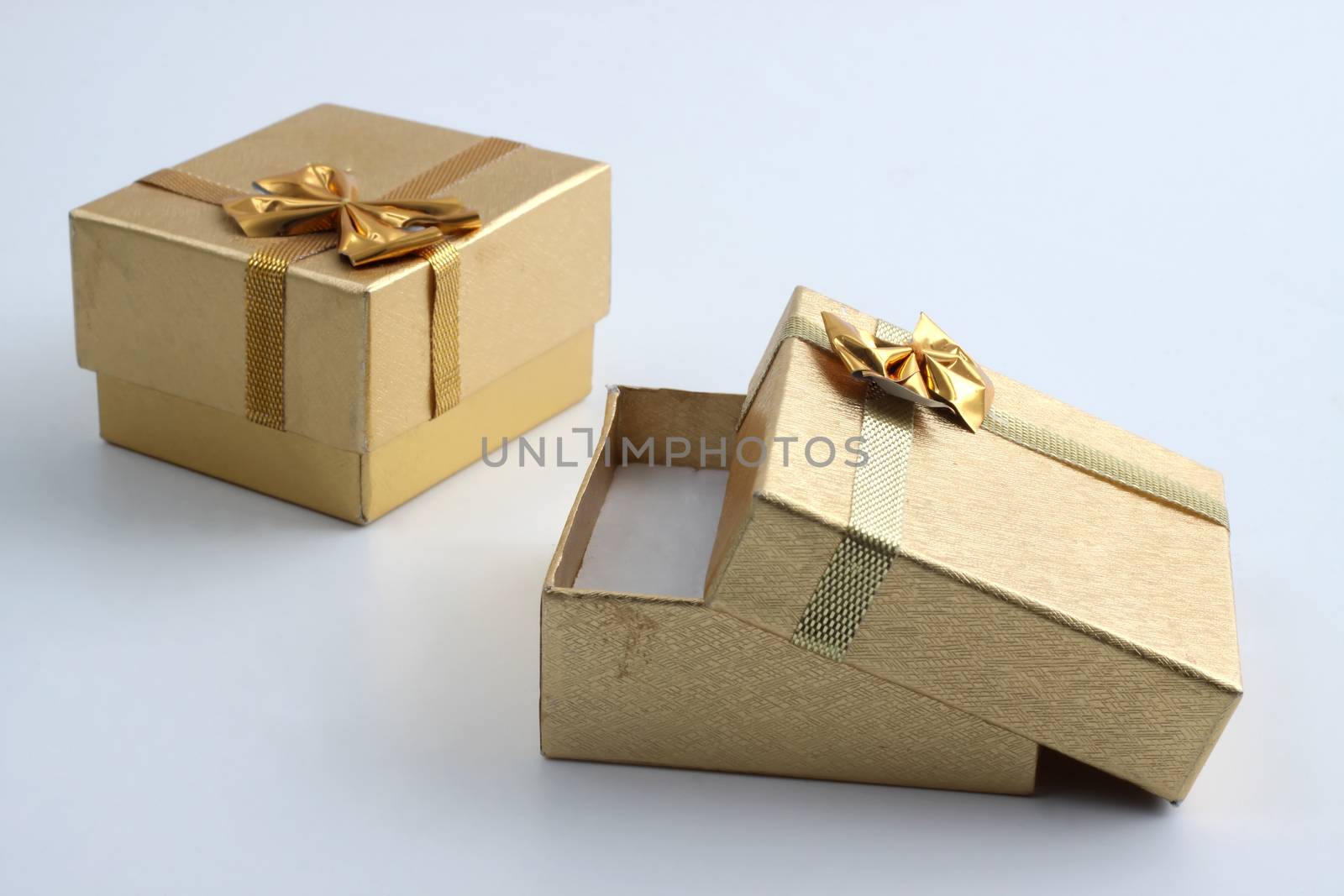 two golden gift ring box one open empty inside on white background