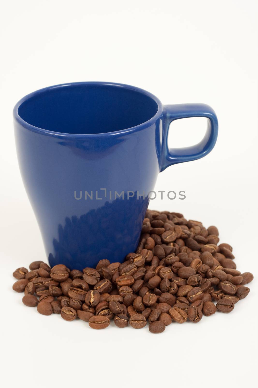 blue coffee cup with some coffee beans around