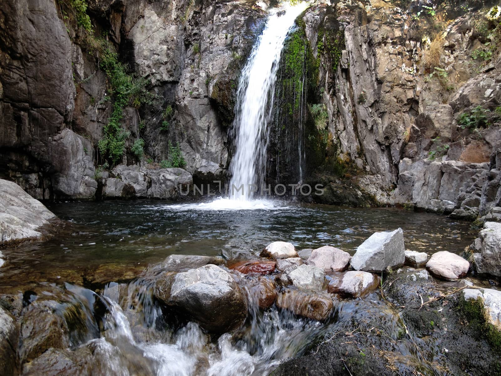 Water falls down and can be seen close to the flow of water on the rocks