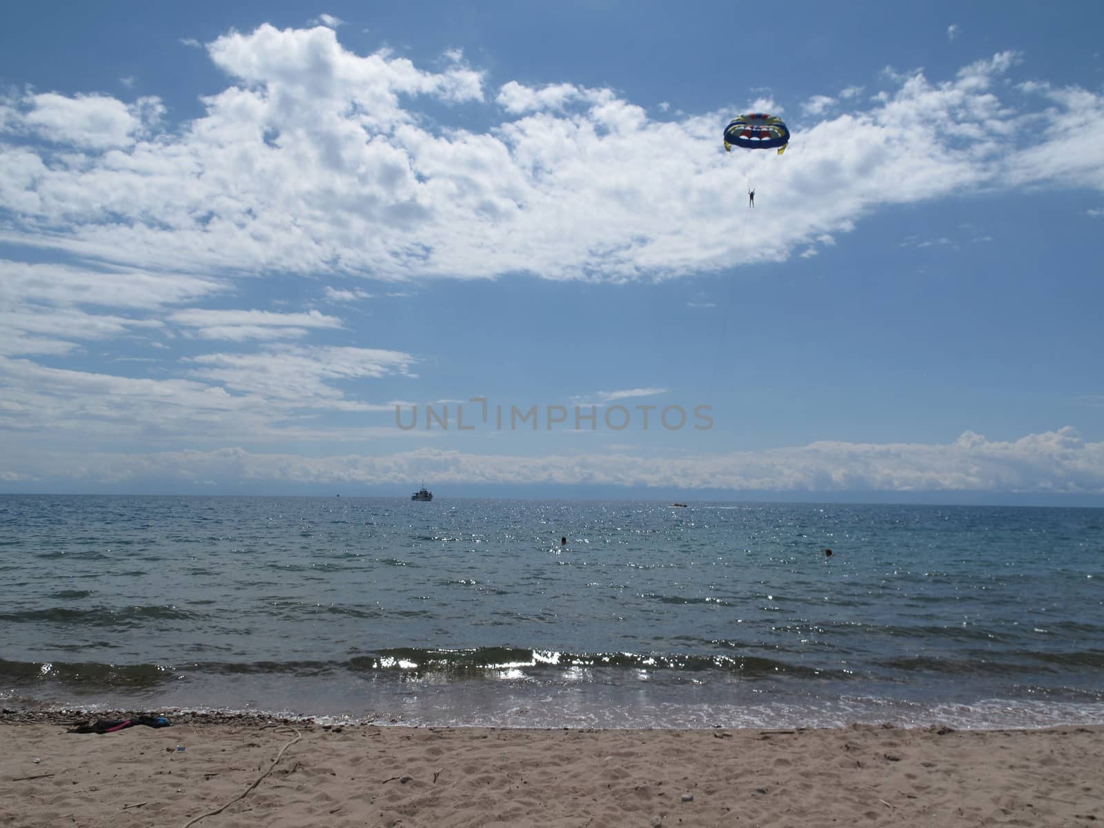 skydiver in the sky above the sea by flydre