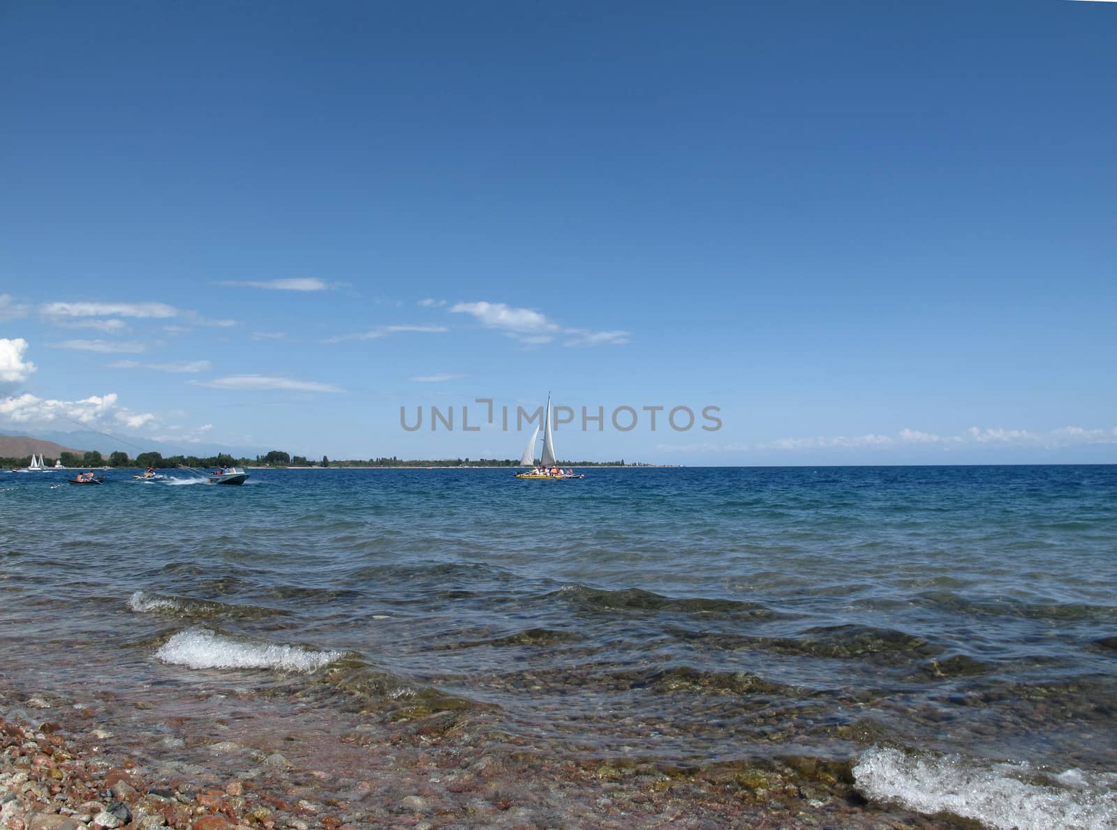  floating sailboat and motor boat on the lake and next wave