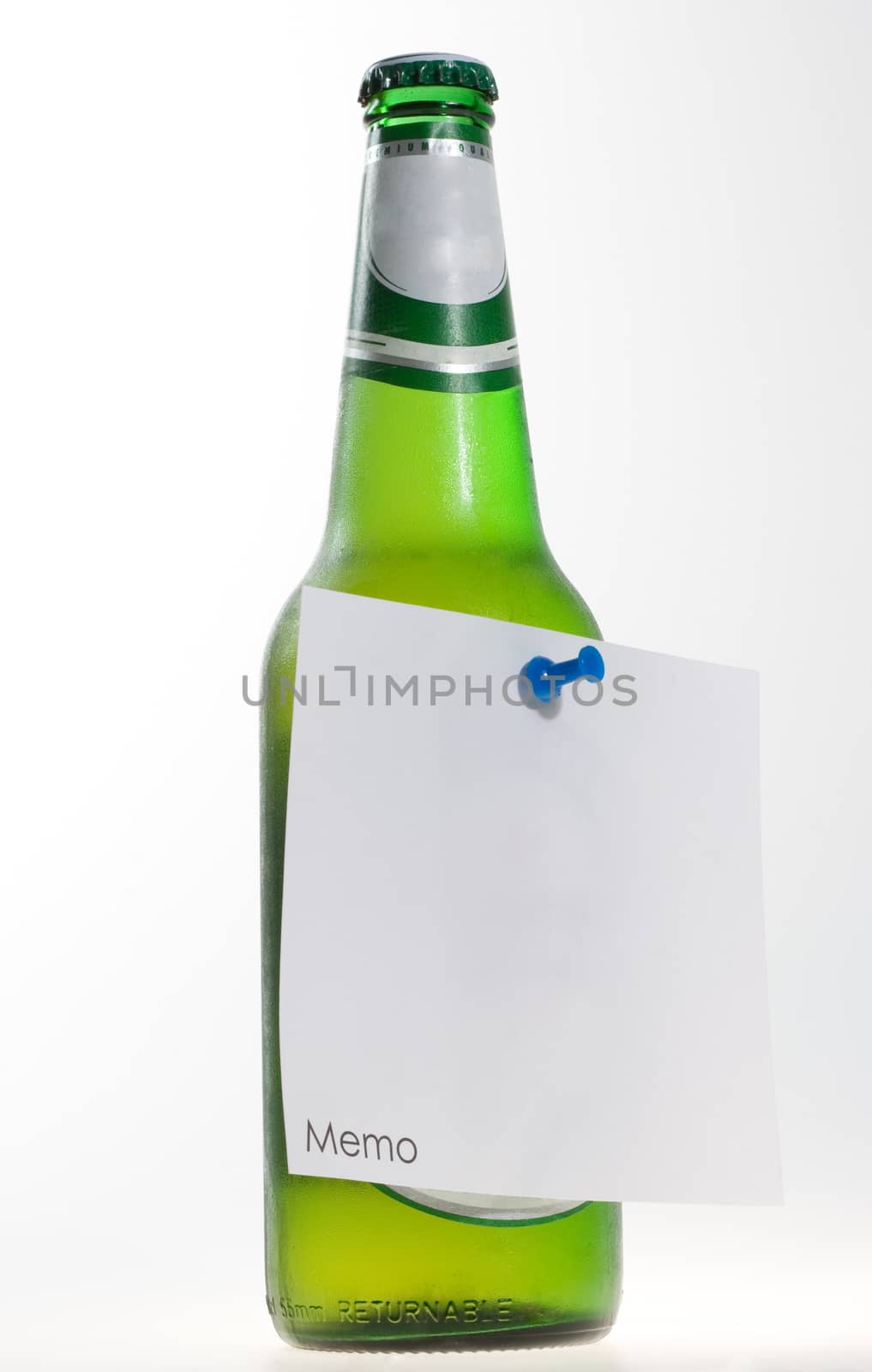 green beer bottle with memo note and a pin