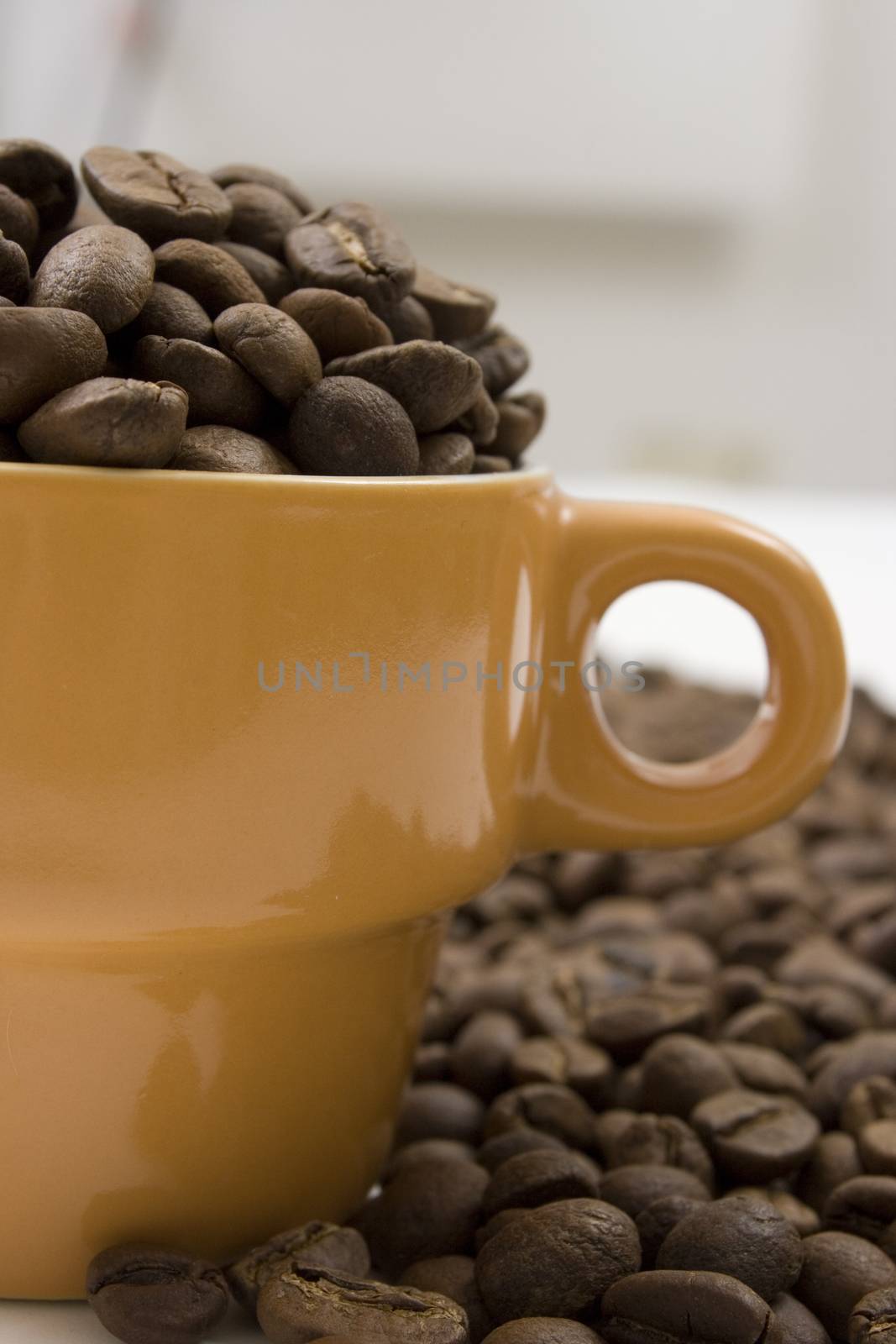 side view of oranje coffee cup with handle full of coffee beans