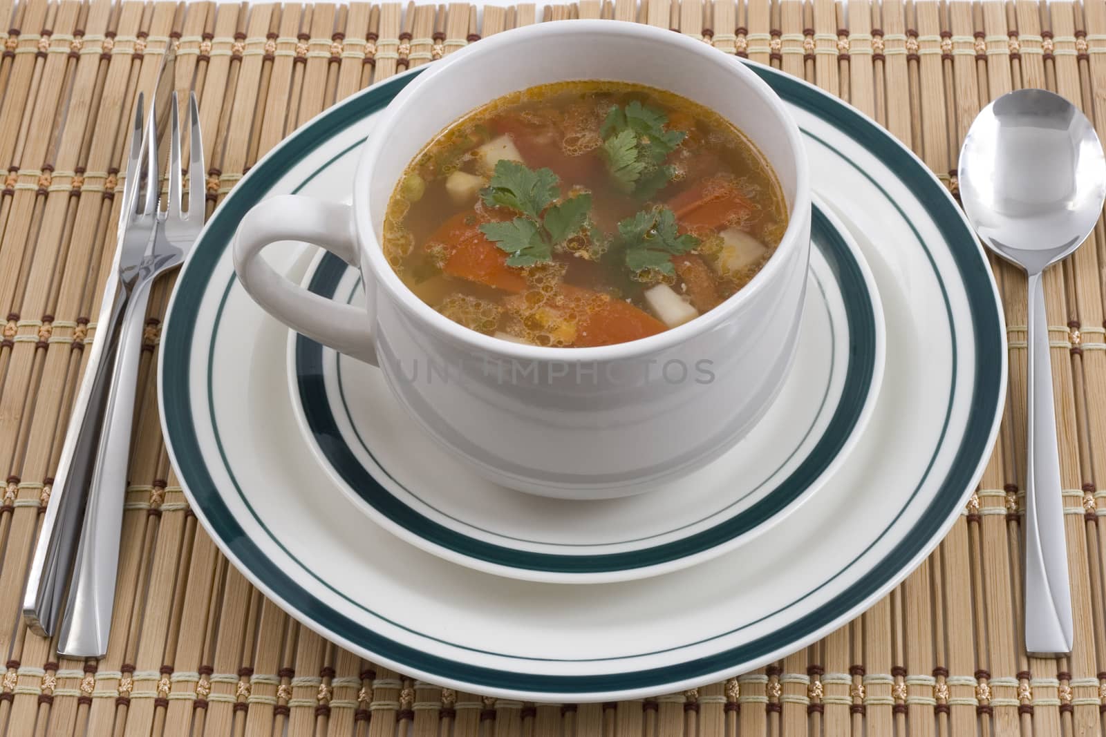 vegetable soup on plates with spoon fourk and knife