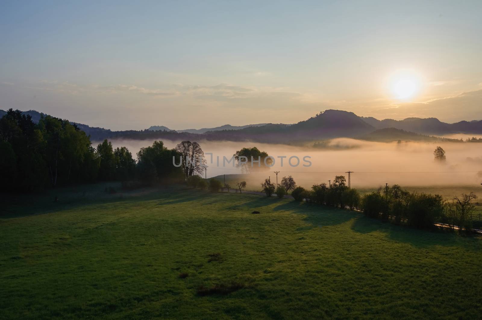 Autumn landscape with hills and forests in sunny morning mist