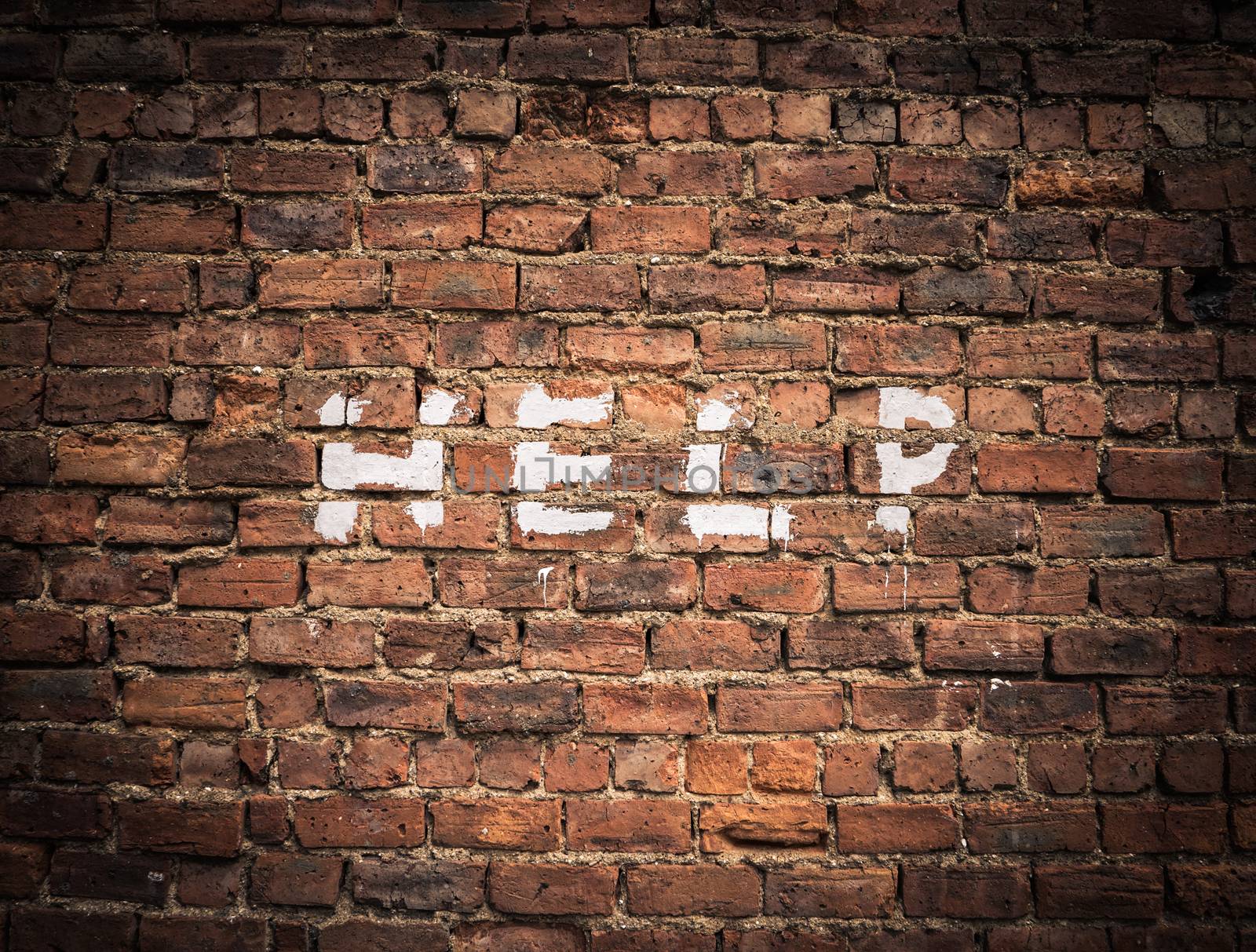 The Word Help Written As Graffiti On A Vintage Red Brick Wall