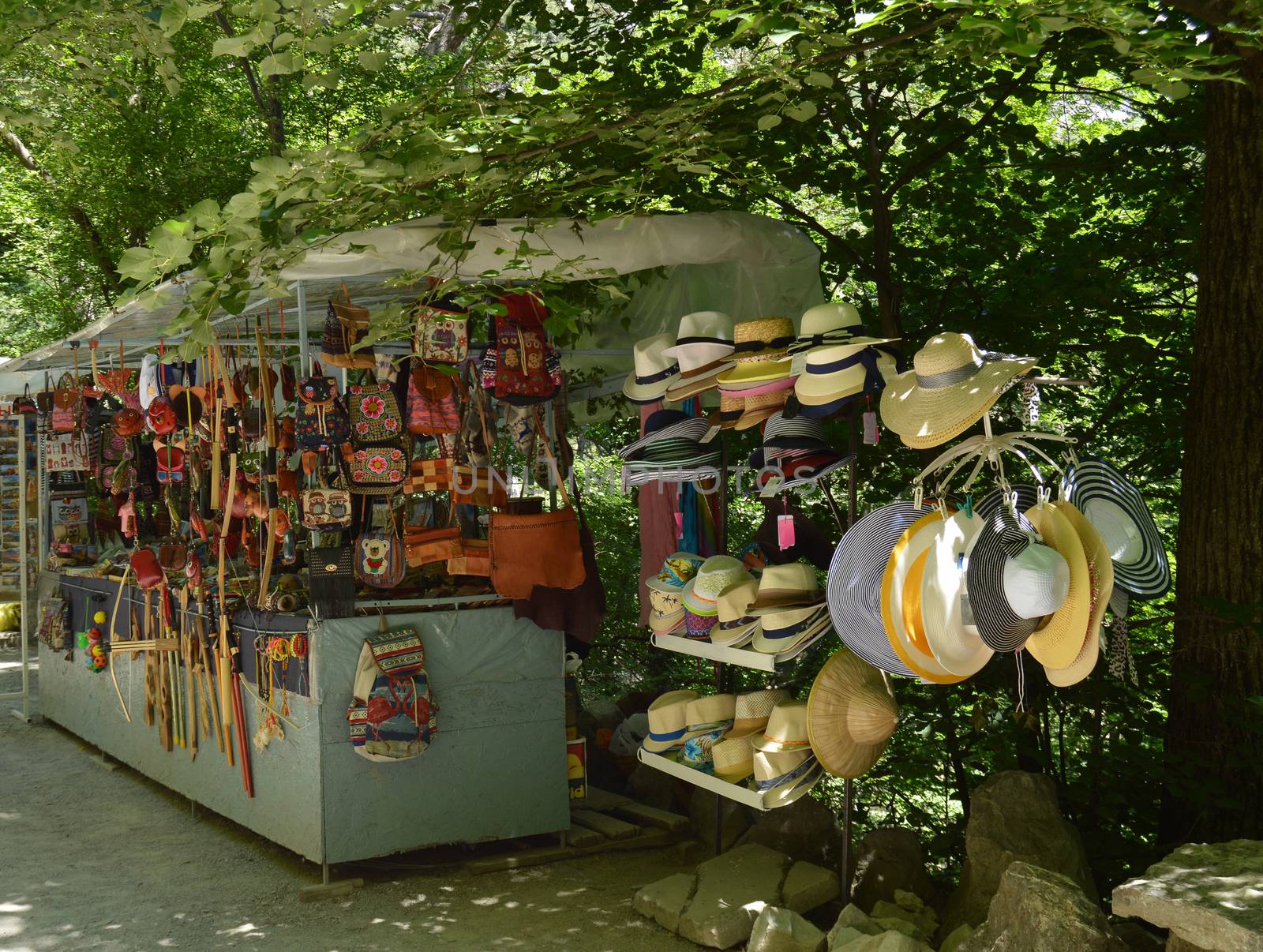 Outdoor souvenir kiosk in the Park with tourist goods hats, bags, backpacks and various accessories by claire_lucia