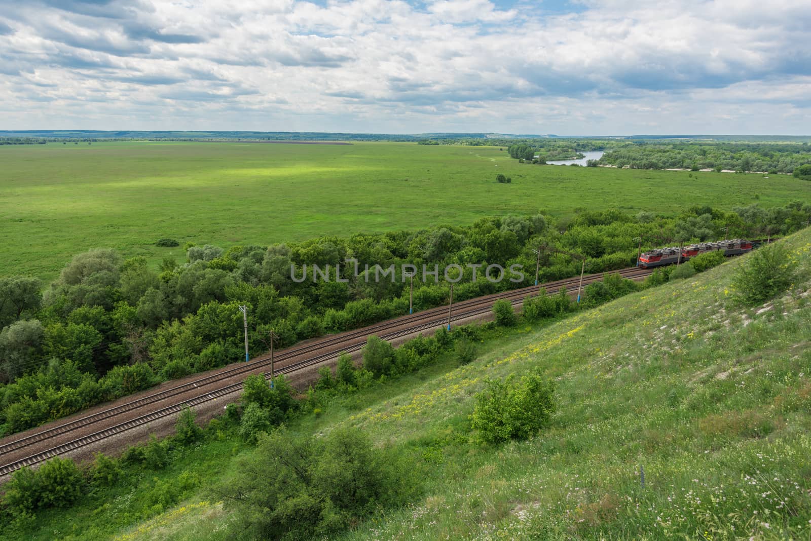 Freight train with locomotives passing by rail in Russia, along the typical Russian landscape, top view.