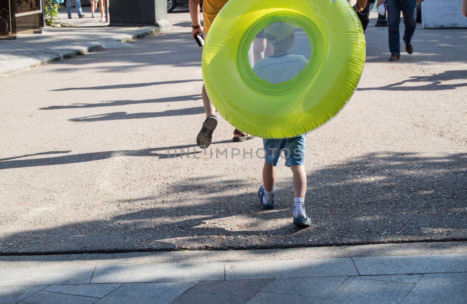 A boy pulls a large green buoy from behind by claire_lucia