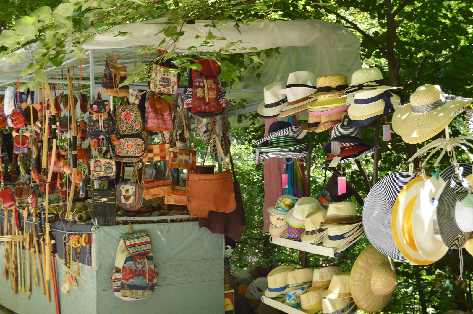 Outdoor souvenir kiosk in the Park with tourist goods hats, bags, backpacks and various accessories.