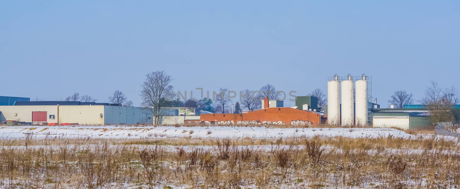 Dutch industry landscape with a warehouse and some white tanks, Majoppeveld a industrial terrain in the city of Roosendaal, The Netherlands