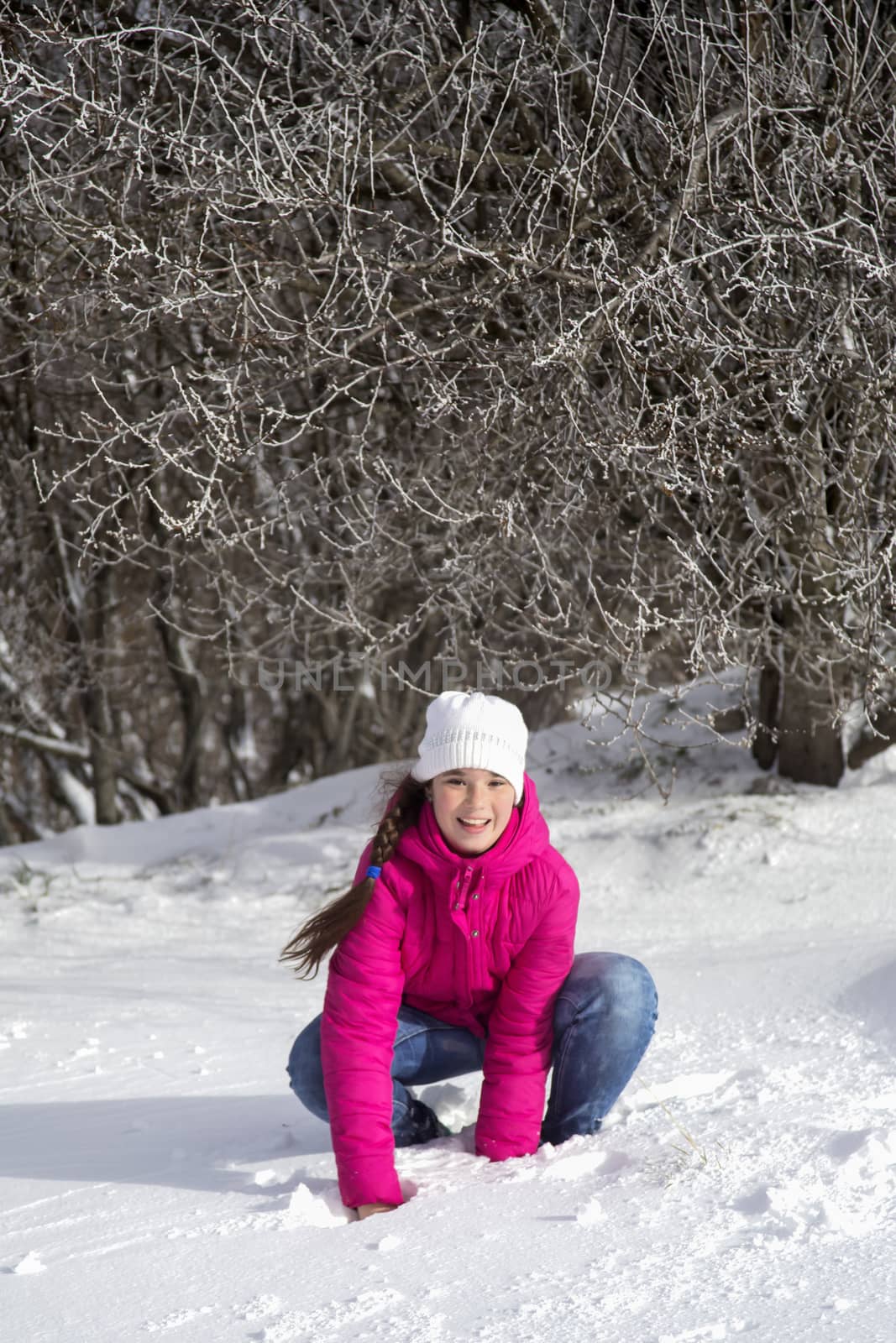 Portrait of a teenage girl in the winter outdoors. playing with snow in the forest.