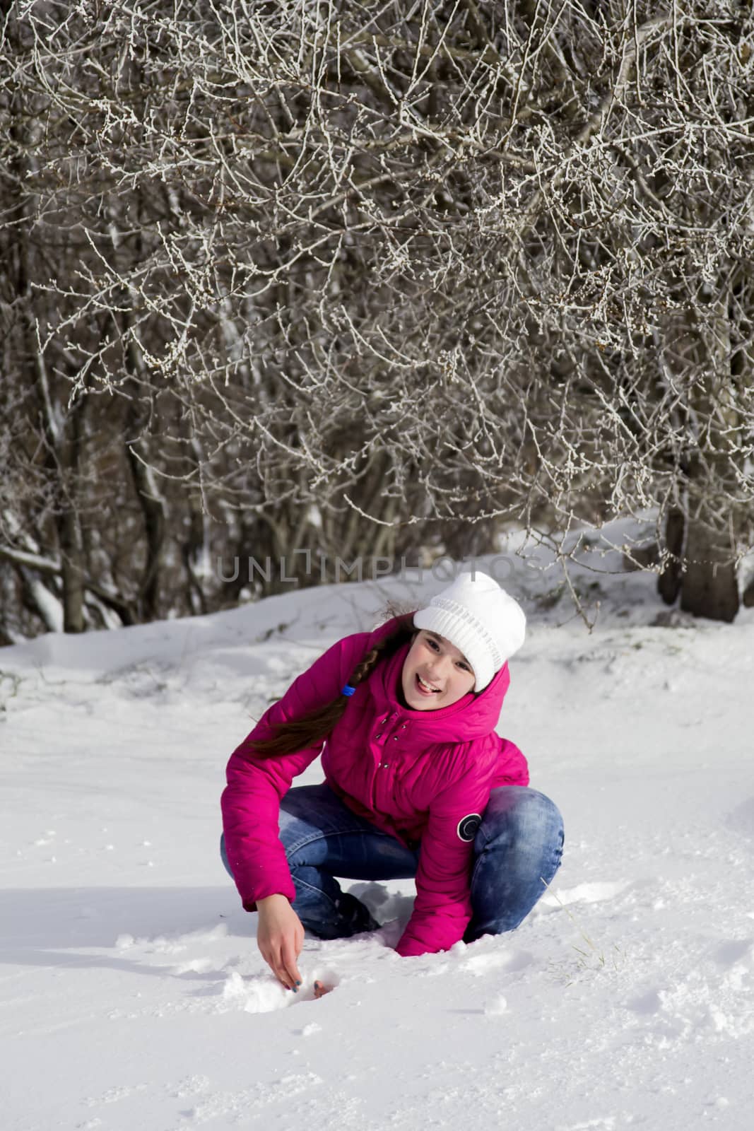 Portrait of a girl in the winter outdoors playing with snow. by Anelik